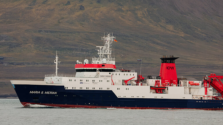 Ein Forschungsschiff mit schwarzem Rumpf, weißem Aufbau und rotem Schornstein