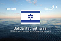 Eine Ansicht vom Meer im Hintergrund, davor die Flagge Israels