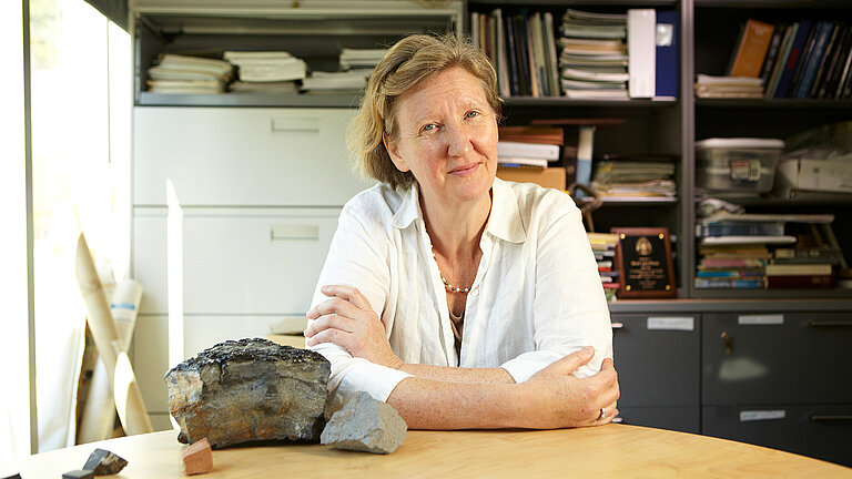 A woman at a desk smiles at the camera