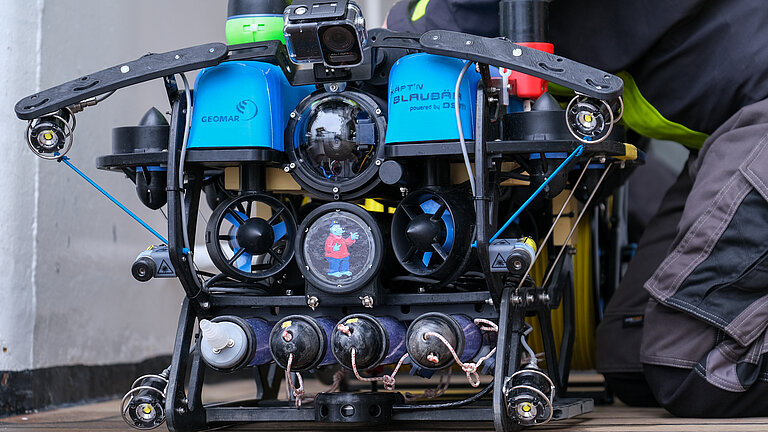 Ein Gerät mit einem Kameraauge, zwei blauen Deckeln und in der Mitte einem Aufkleber mit der Bilderbuchfigur Käpt'n Blaubär drauf