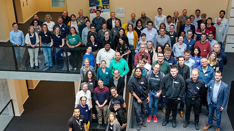 Viele Teilnehmende des HMC-Sommertreffen stehen im Gebäude des GEOMAR Helmholtz-Zentrum für Ozeanforschung Kiel 