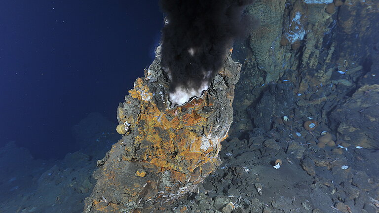 Am Meeresgrund quillt schwarzer Rauch aus einem Gesteinsschlot.
