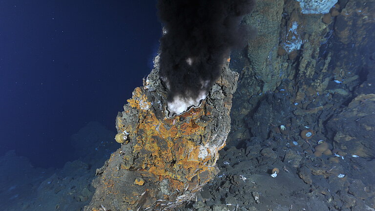 Black smoke billows from a rocky chimney at the bottom of the sea.