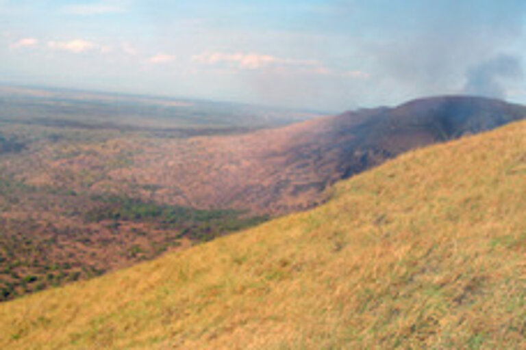 Die Caldera: Inzwischen eine Graslandschaft, rechts sieht man den aktiven Vulkan Masaya, der aus der Caldera gewachsen ist. 