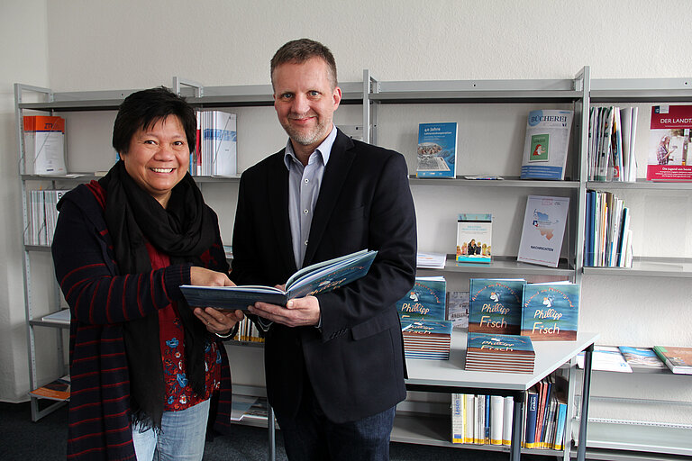 Dr. Sally Soria-Dengg vom Sonderforschungsbereich 754 und Oke Simons, stellvertretender Direktor der Büchereizentrale Schleswig-Holstein, mit dem Bilderbuch "Phillipp Fisch - Atemnot am Meeresgrund". Foto: Joachim Dengg/GEOMAR