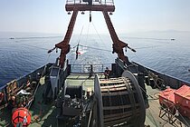 Das Heck eines Schiffes, dahinter Messkabel auf dem Wasser