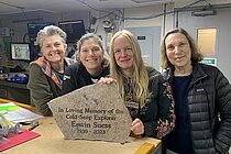 Four researchers stand at a table and present the memorial stone for Professor Dr Erwin Suess.