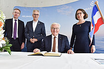 Bundespräsident Frank-Walter Steinmeier trägt sich bei seinem Besuch am GEOMAR ins Gästebuch ein. Rechts: GEOMAR-Direktorin Professorin Dr. Katja Matthes, links Daniel Günther, Ministerpräsident des Landes Schleswig-Holstein, und Frank Spiekermann, Verwaltungsdirektor des GEOMAR.