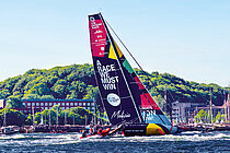 Eine Rennyacht vor Stadtsilhouette