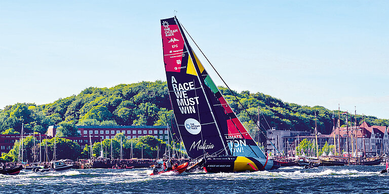 Eine Rennyacht vor Stadtsilhouette