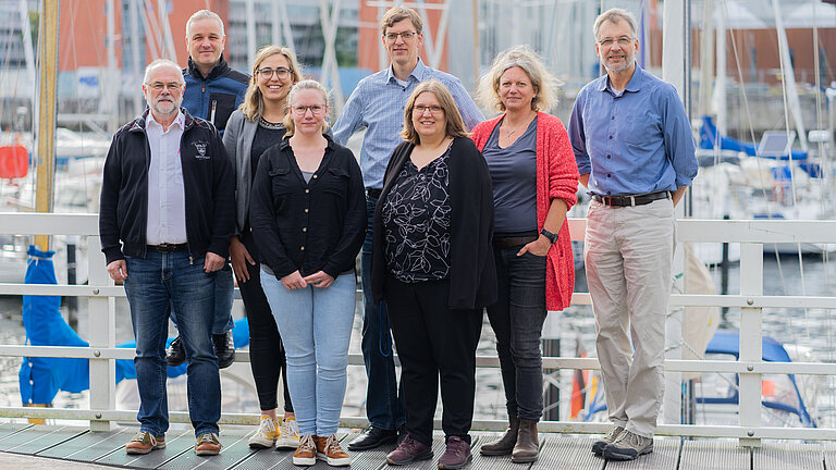 Eine Gruppe Menschen schaut lächelnd in die Kamera