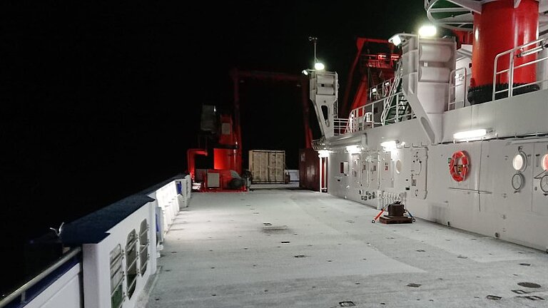 Schnee bedeckt das Deck eines Forschungsschiffes in der Nacht