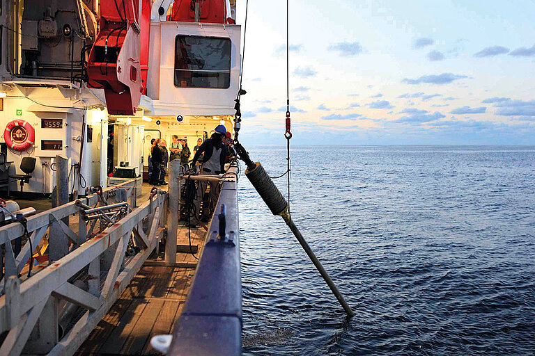 Ein Schwerelot wird von Bord eines Forschungsschiffs ausgebracht. Bestückt mit tonnenschweren Gewichten dringt es in den Meeresboden ein und wird mitsamt des im Rohr eingeschlossenen Sediments wieder an Bord geholt und dann beprobt. Foto: Elgar Esser
