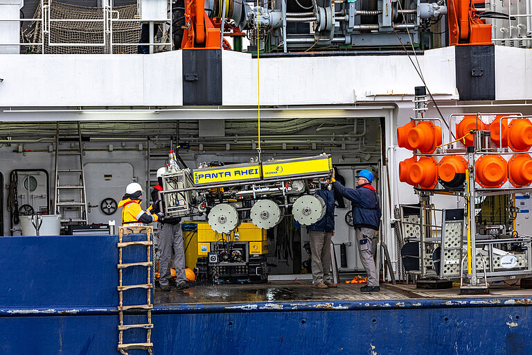 Der DSR PANTA RHEI kommt nach erfolgreichem Test wieder an Deck der FS ALKOR. Im Hintergrund sind der Tiefsee-Crawler VIATOR und rechts ein Tiefsee-Lander zu sehen. Foto: Florian Huber.