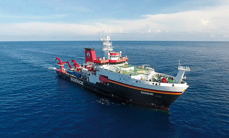 Ein großes Forschungsschiff auf dem Meer, von schräg oben aufgenommen