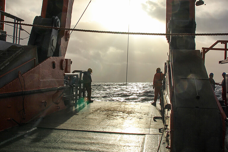 Sie Sonne bricht über der SONNE durch die Wolken.