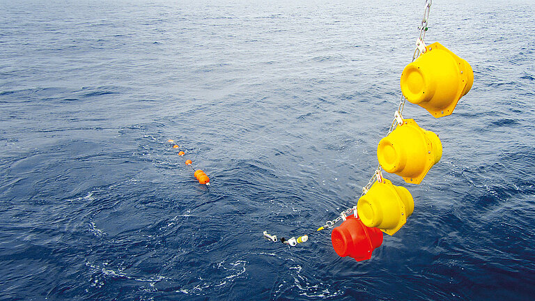 Behind the stern, the mooring is pulled through the water like a kind of string of pearls that grows steadily longer.