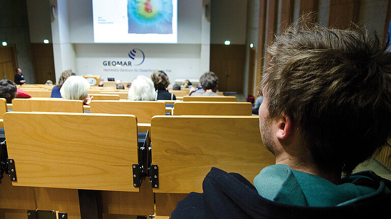 Blick in den GEOMAR Hörsaal mit Menschen. Teaserbild als Link zu den Veranstaltungseiten. 