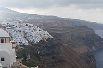 Steile Hänge fallen zum Meer ab, oben auf der Kante sind viele weiße Häuser dicht an dicht gebaut