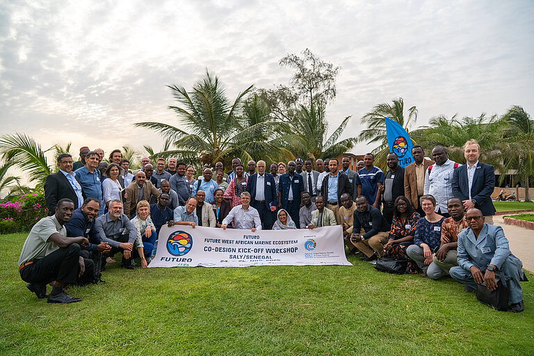 Menschen versammeln sich zum Gruppenfoto, sie halten ein Banner in der Hand