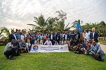 Menschen versammeln sich zum Gruppenfoto, sie halten ein Banner in der Hand