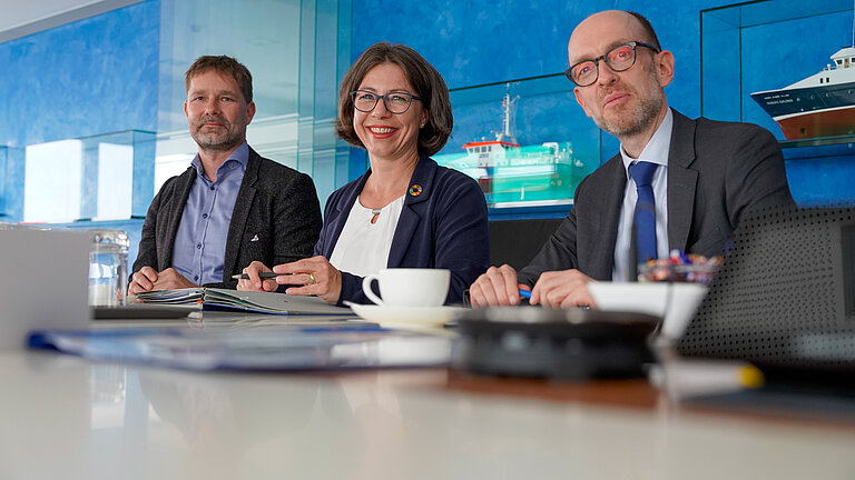 Drei Personen an einem Tisch