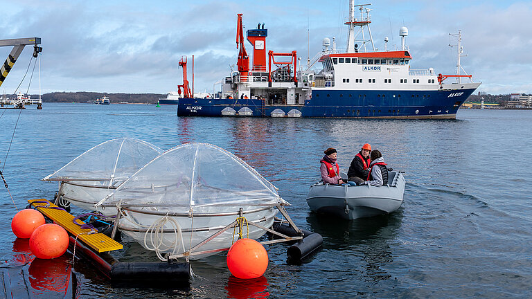 The mesocosms are towed towards the pier by inflatables