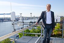 Ein Mann vor der Kulisse eines Hafens