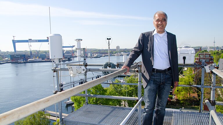 Ein Mann vor der Kulisse eines Hafens