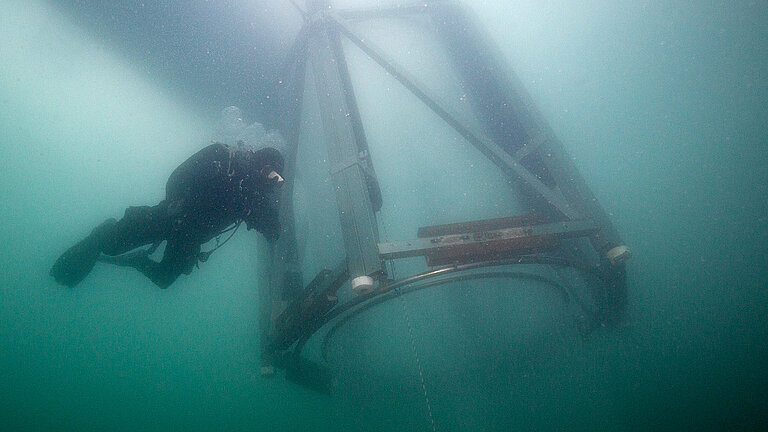 Ein Forschungstaucher bei der Arbeit an einem Mesokosmos.