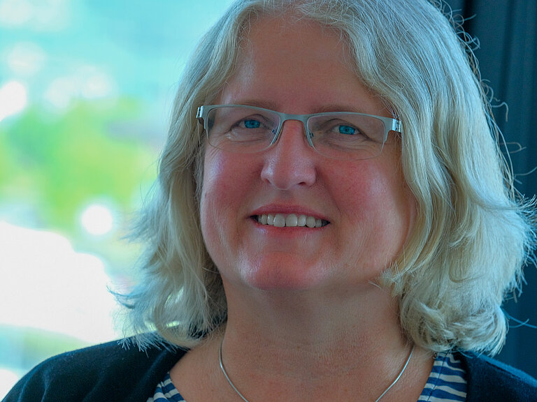 A woman smiles into the camera