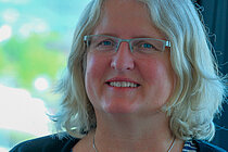 A woman smiles into the camera