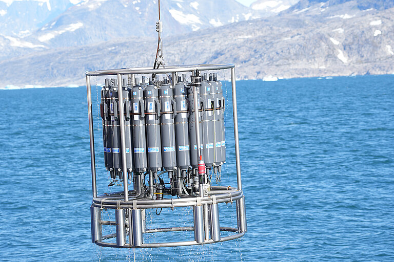 Kranzwasserschöpfer. Zu sehen ist ein silbernes Gestell mit grauen Behältern. 