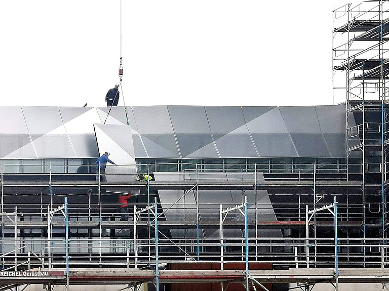 Anbringung der Fassadenelemente aus Aluminium-Lochblech am Turm 4 im Herbst 2019.