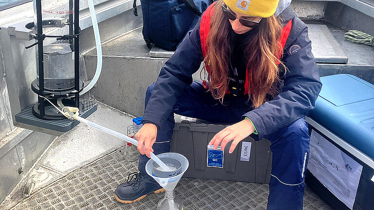 The water sample is filled into sample bottles for examination in the laboratory using a hose from the container and labeled. 