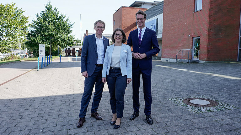 Eine Frau und zwei Männer posieren für ein Foto