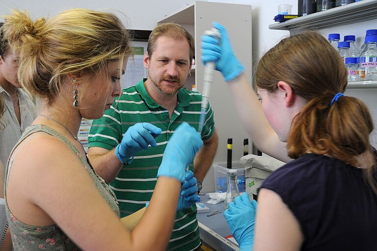 Jessica Tongue und Julia Daiß bereiten gemeinsam mit Stefan Krause vom IFM-GEOMAR das Anfärben von Bakterien vor.