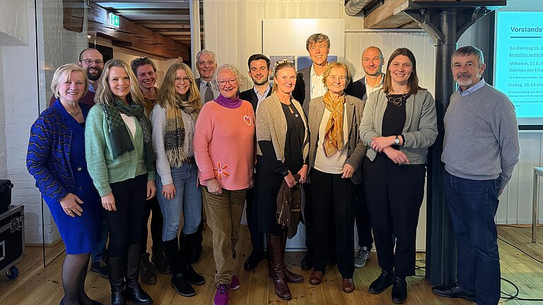 Eine Gruppe Menschen lächelt in die Kamera