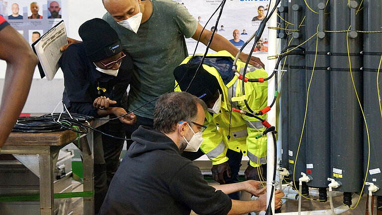 Während der WASCAL Floating University werden Wasserproben zur weiteren Untersuchung aus einem Kranzwasserschöpfer genommen. 